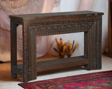 Wooden console table with intricate carvings on a plain background