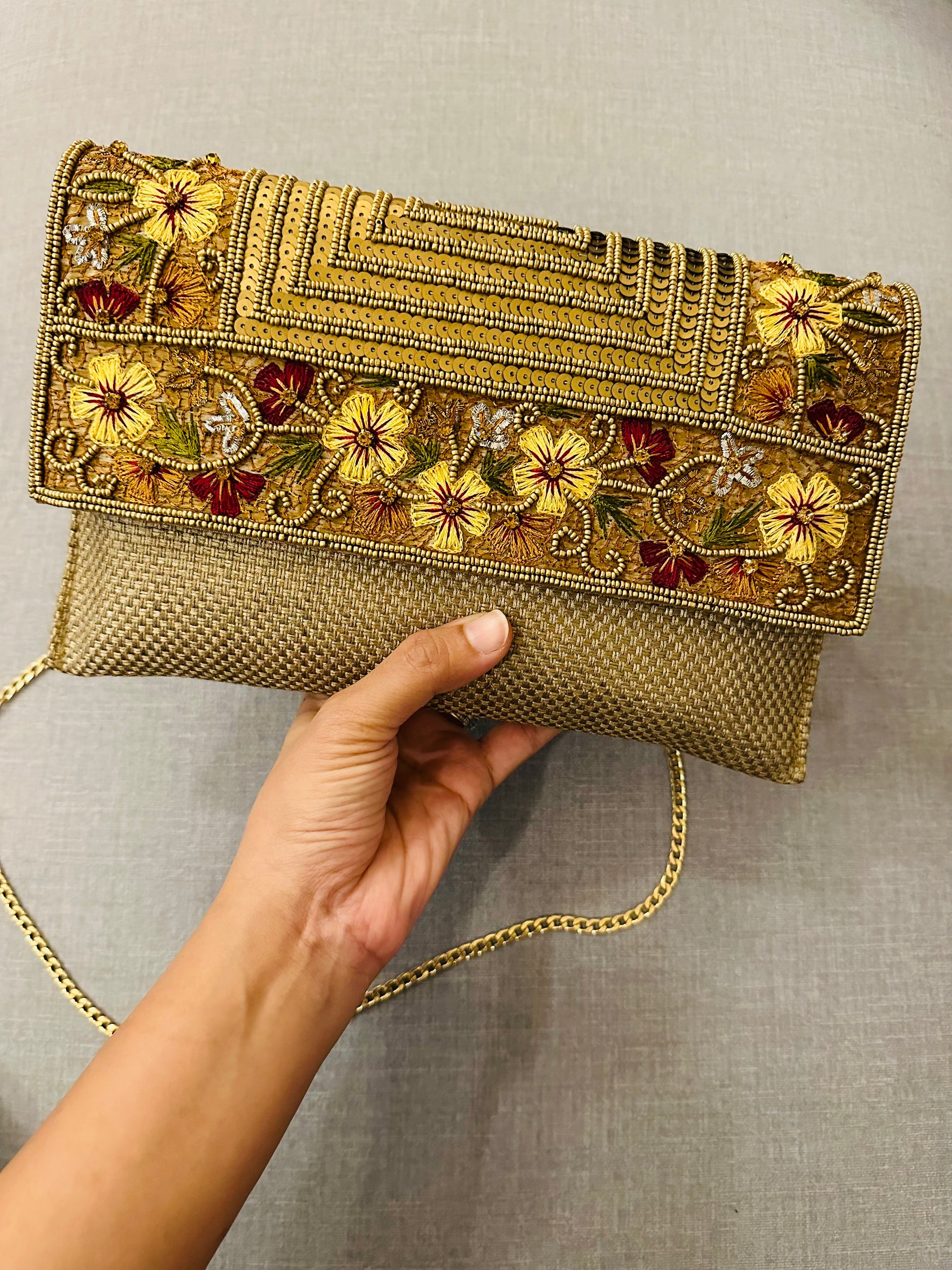 Zardozi clutch with detachable metal chain showing versatile sling and clutch functionality