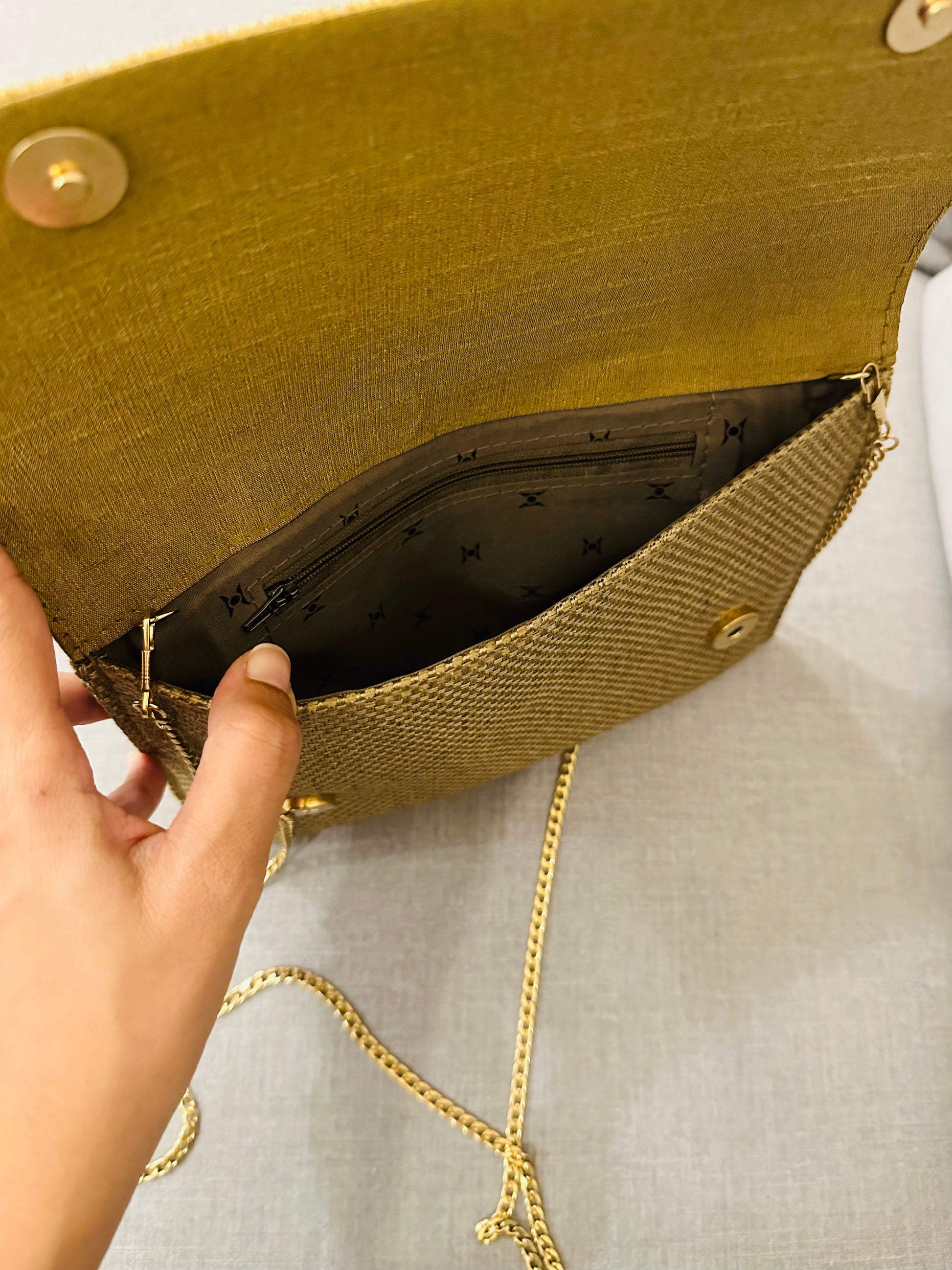 Interior view of jute clutch displaying satin lining and zipper pocket for essentials storage