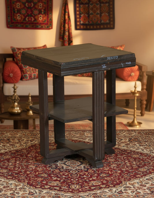 Wooden side table with two shelves on a textured floor and white wall background