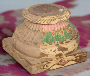 Decorative wooden pedestal with artistic carvings on a tiled floor teak tesu candle
