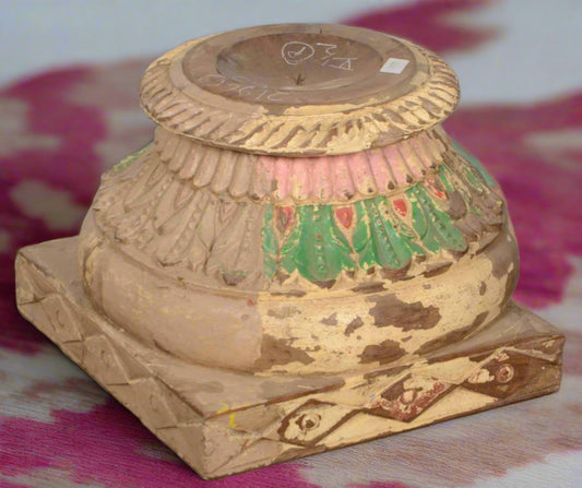 Decorative wooden pedestal with artistic carvings on a tiled floor teak tesu candle