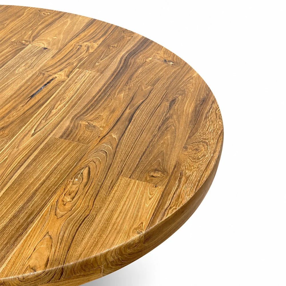 Close-up of a round wooden table top with a rich warm brown grain pattern, showing the edge of the table against a clean white background.