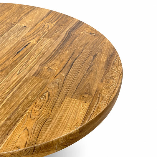 Close-up of a round wooden table top with a rich warm brown grain pattern, showing the edge of the table against a clean white background.