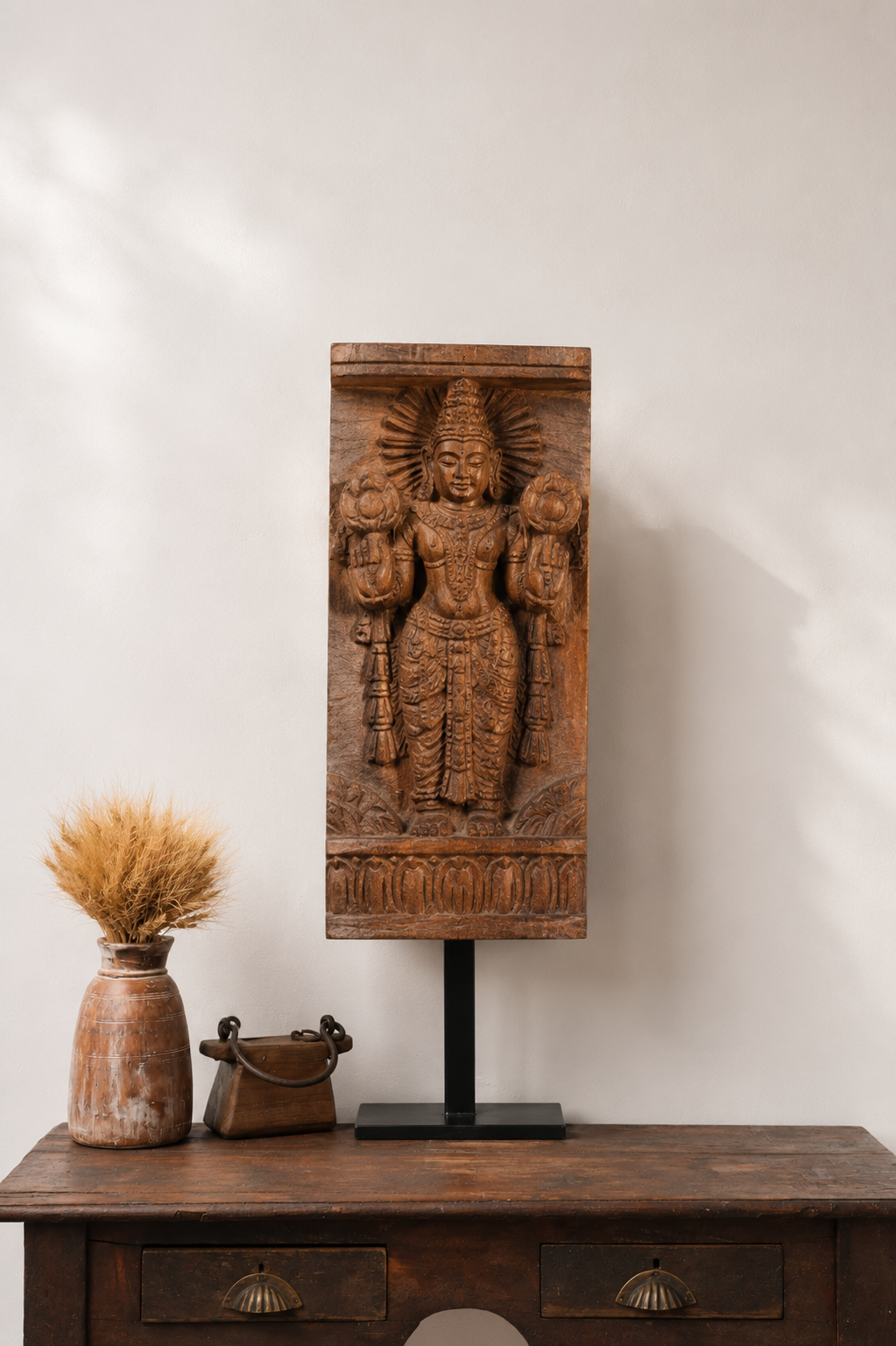 Hand-carved reclaimed wood architectural bracket featuring a traditional divine figure, displayed on a black iron stand.
