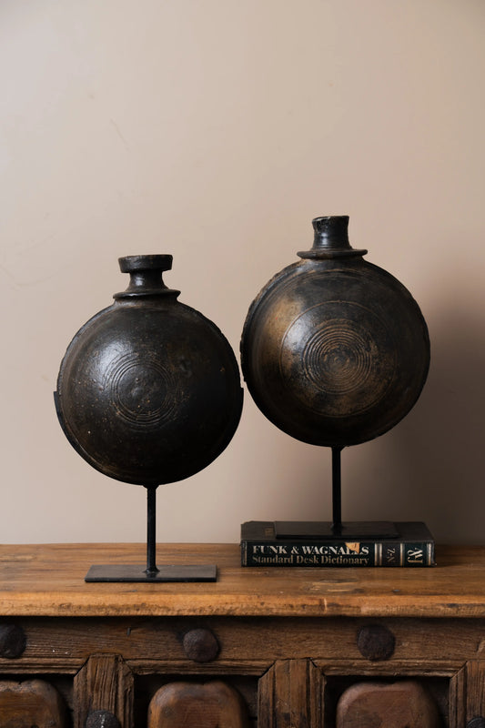 Antique black clay pot Iron stand Vintage charm Contemporary flair Rustic decor Indoor/outdoor display Focal point decor Garden decor Patio styling Versatile design Sophisticated elegance Traditional craftsmanship Artisanal touch Home decor trends Minimalist chic Eclectic charm