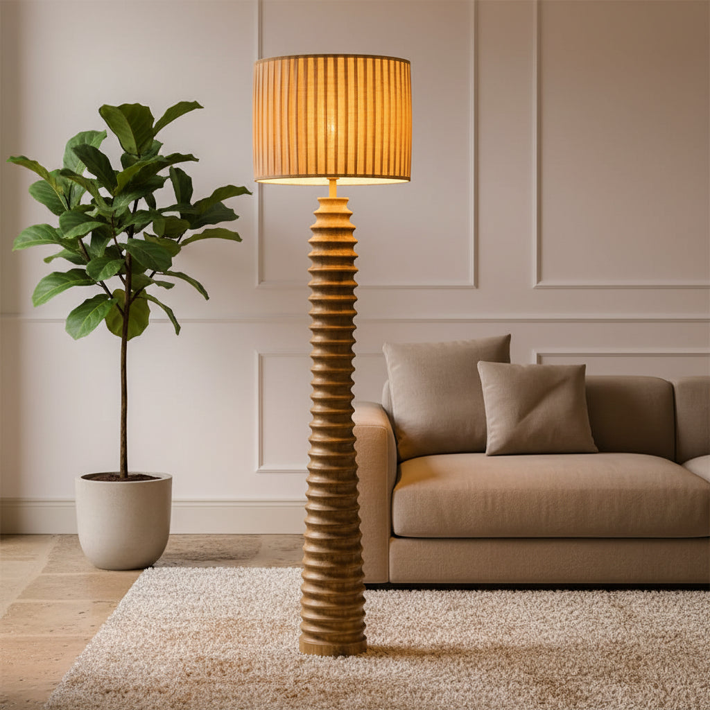 Tall floor lamp with a textured base and striped shade in a room with wooden floors and doors.