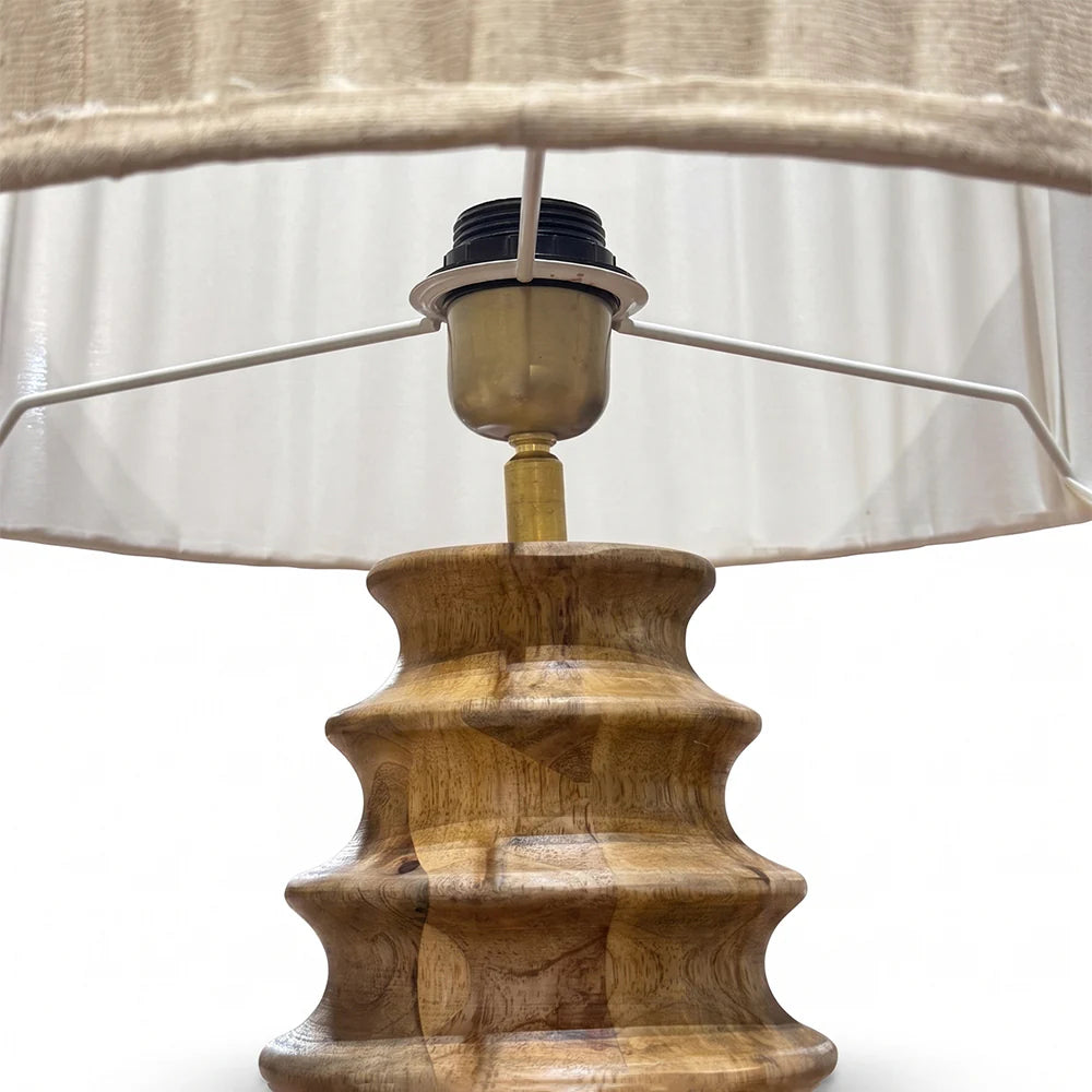 Wooden lamp base with a beige lampshade on a white background