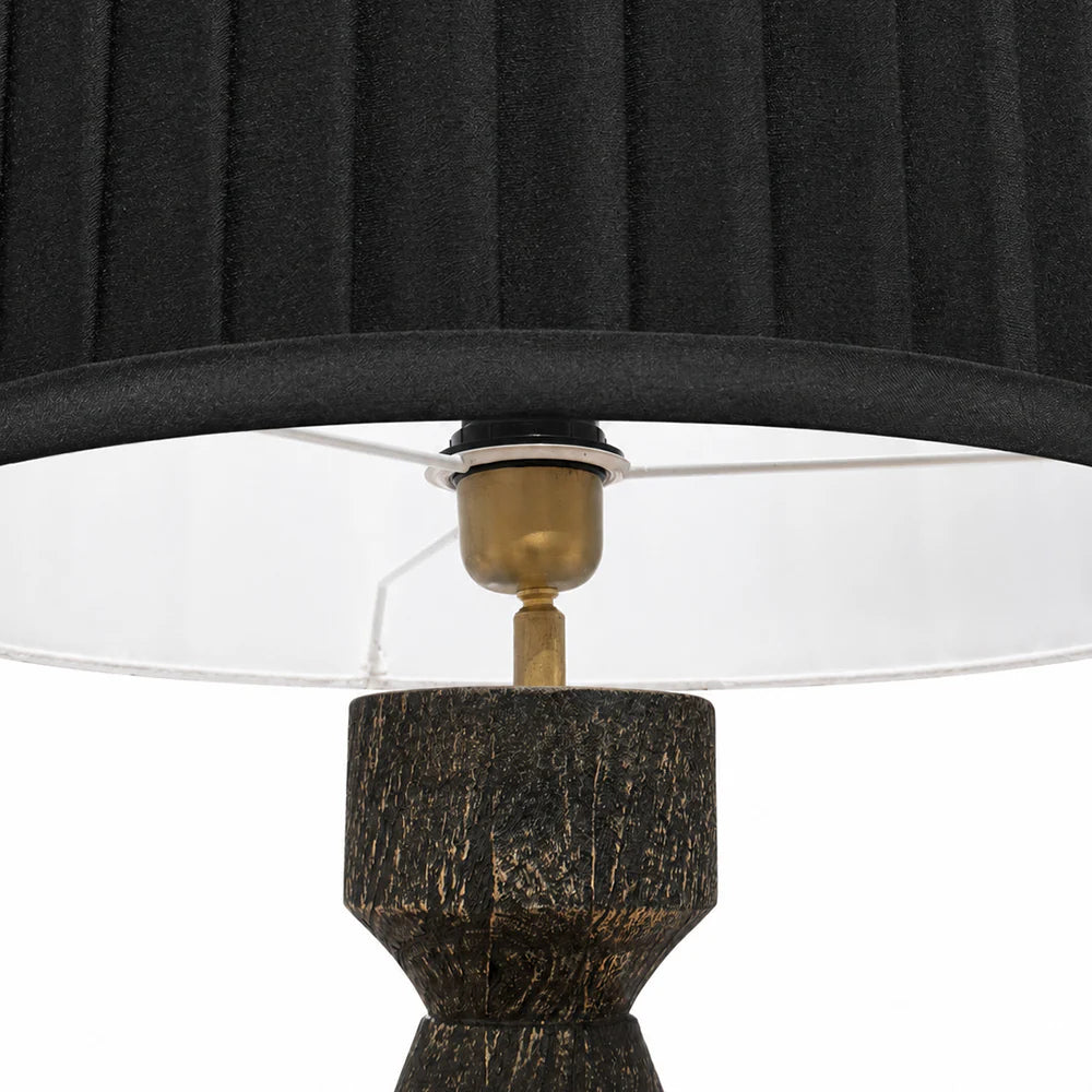 Close-up of a lamp with a black shade and textured black base on a white background