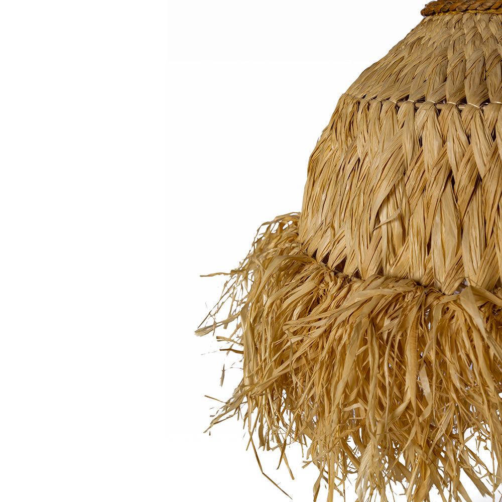 Close-up of a woven straw hat with fringes on a white background