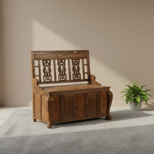 Wooden bench with intricate carvings against a yellow wall
