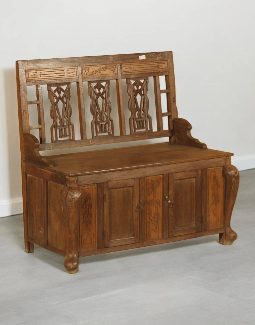 Wooden bench with intricate carvings on a plain background