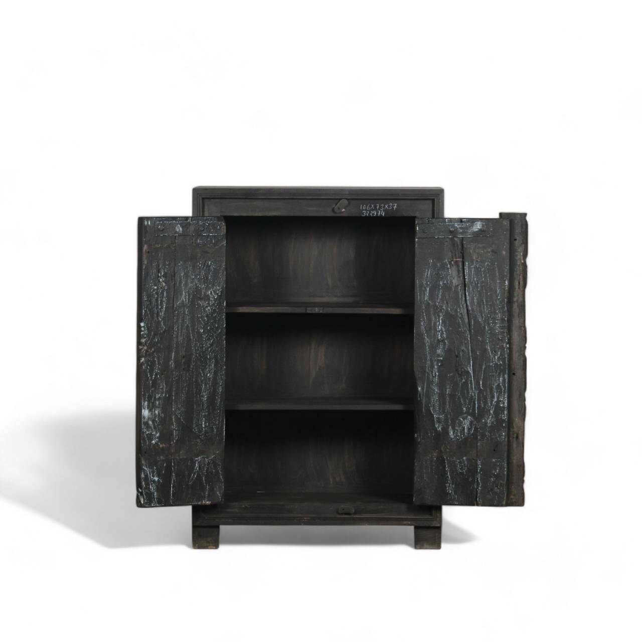 The sturdy double doors, adorned with subtle metal accents and distressed detailing, open to reveal spacious shelving, perfect for organized storage.