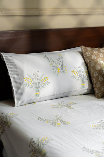 Floral-patterned bed sheets and pillow on a bed with a wooden headboard.
