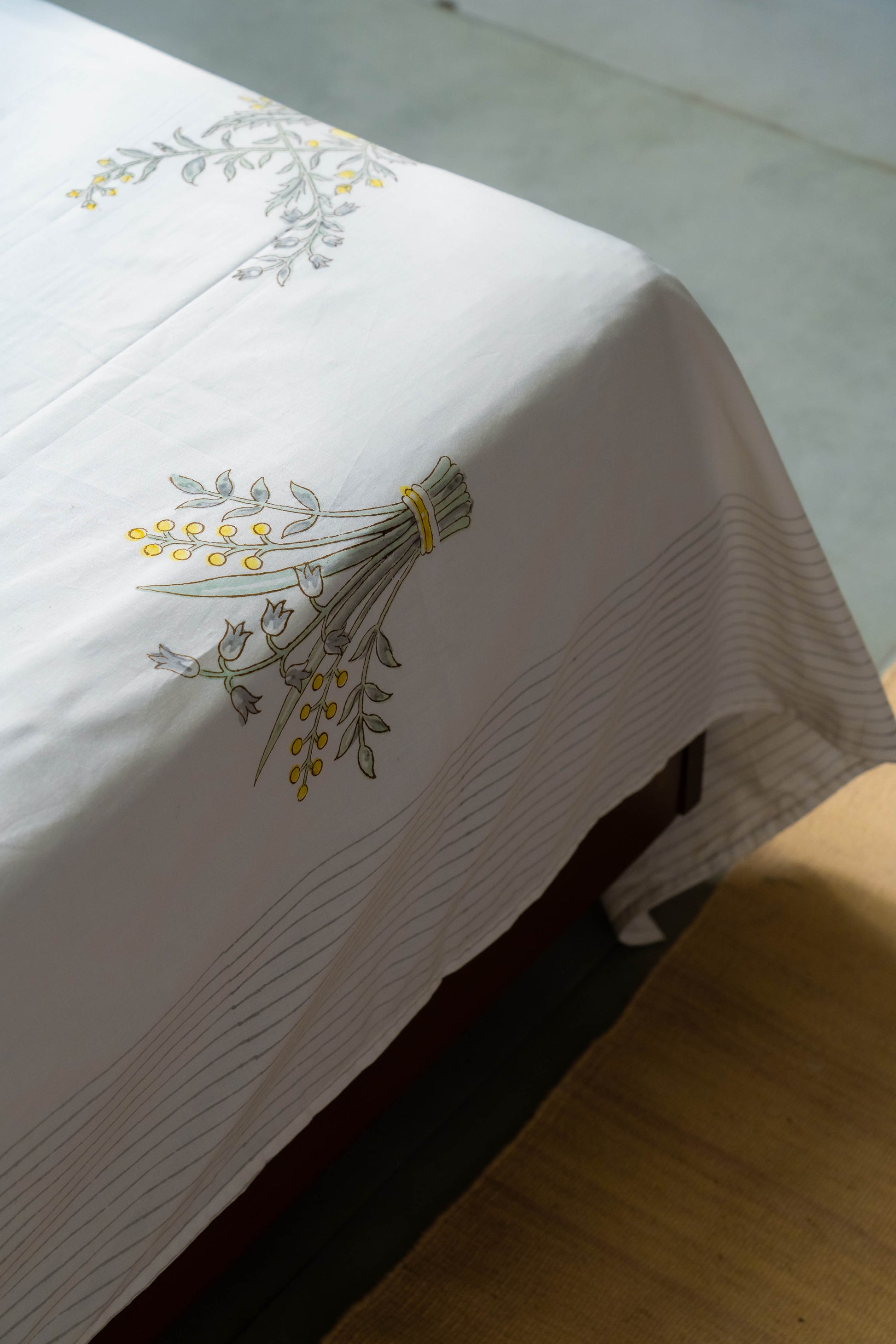 White tablecloth with floral embroidery on a wooden surface