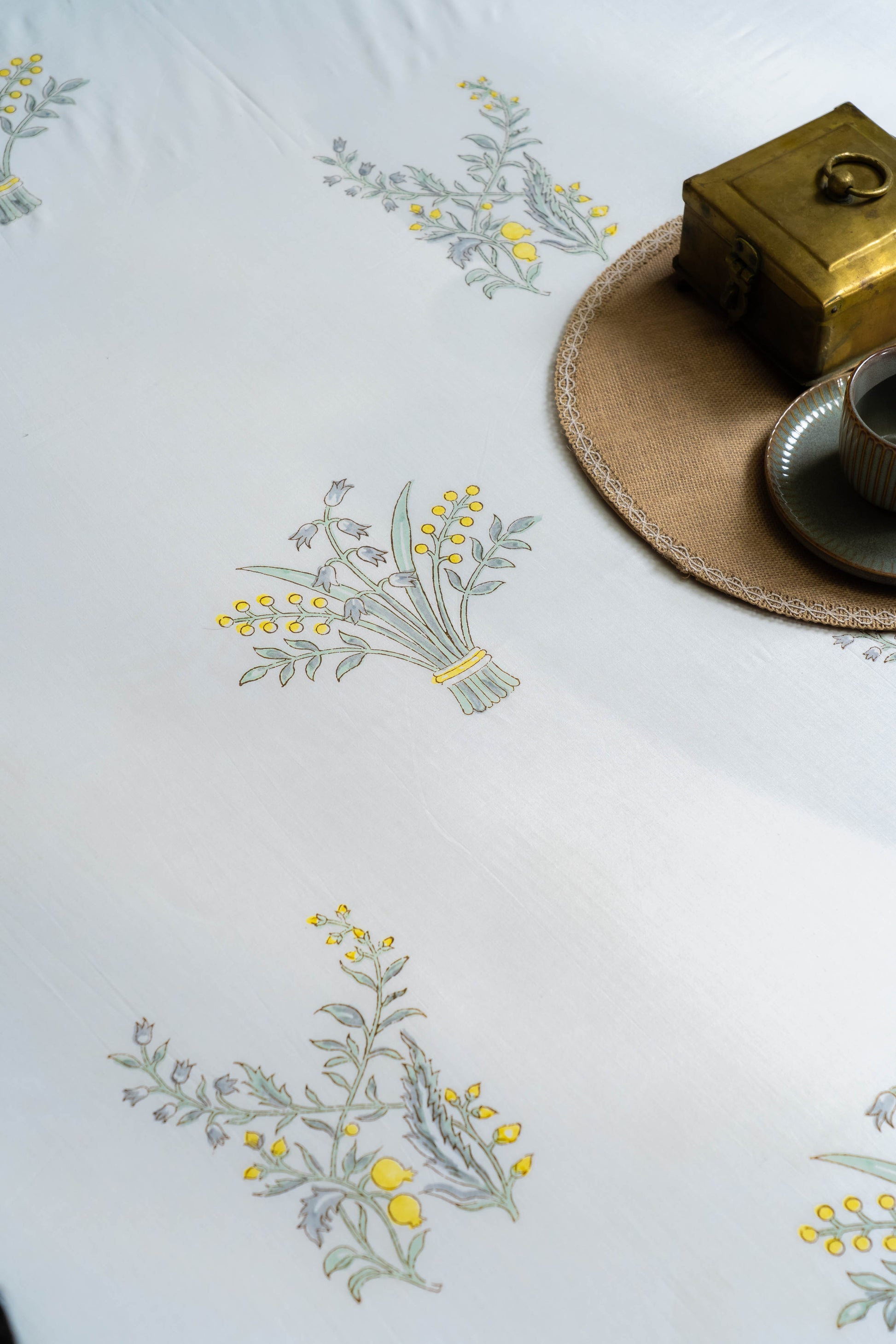 Embroidered tablecloth with floral patterns on a white surface.