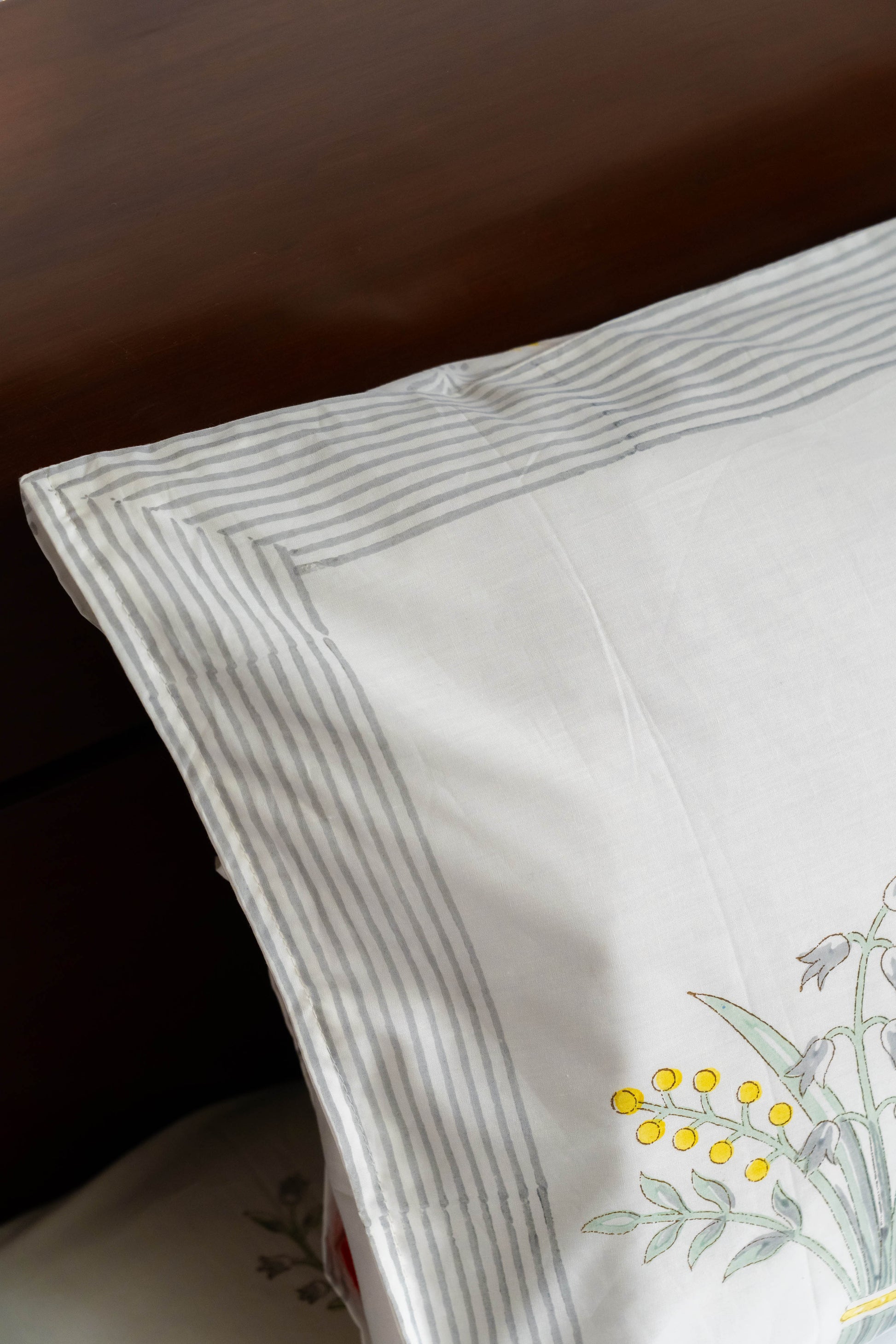 Embroidered pillow with floral design on a wooden surface