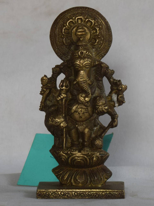 Intricately crafted, this idol features Lord Ganesha standing atop a lotus pedestal, symbolizing purity and spiritual elevation. With four arms holding sacred items and a radiant halo (Prabhavali) crowning his head, this form reflects both his divine power and royal presence.
