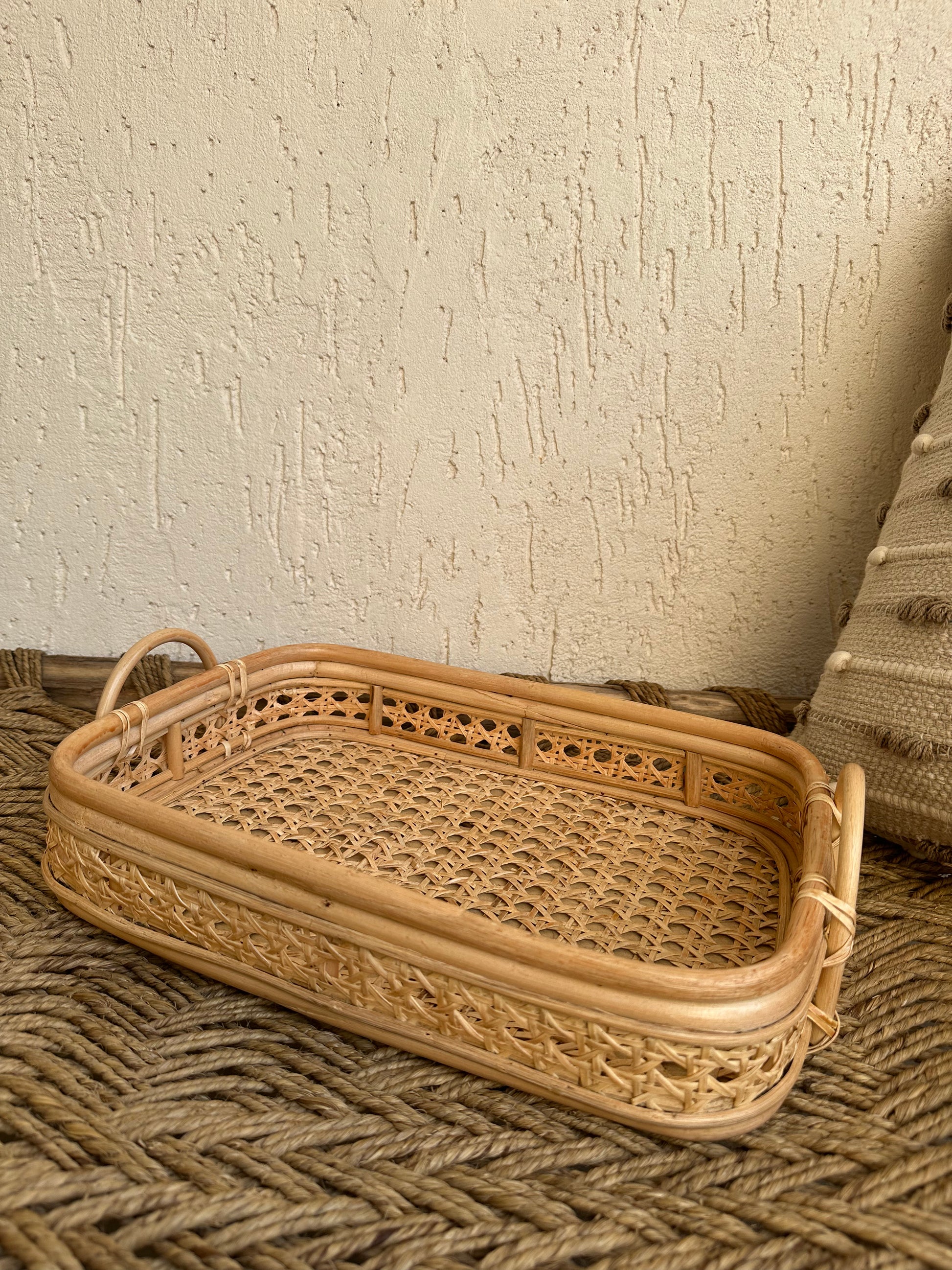 This lovely rattan tray is a must have to create stylish spaces. In effortlessly chic hand-woven cane with detailed wicker pattern makes it an eye catcher. This multipurpose tray look gorgeous on a coffee table with plants and candles , storage for blankets in living room or place them in bathroom with rolled up towels to merge functionality with stylish charm. TESU