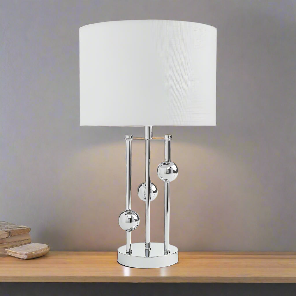 The elegant silver finish adds a sleek, contemporary touch, while the fabric diffuser casts a warm, inviting light—perfect for creating a cozy atmosphere in your living room, bedroom, or study.
