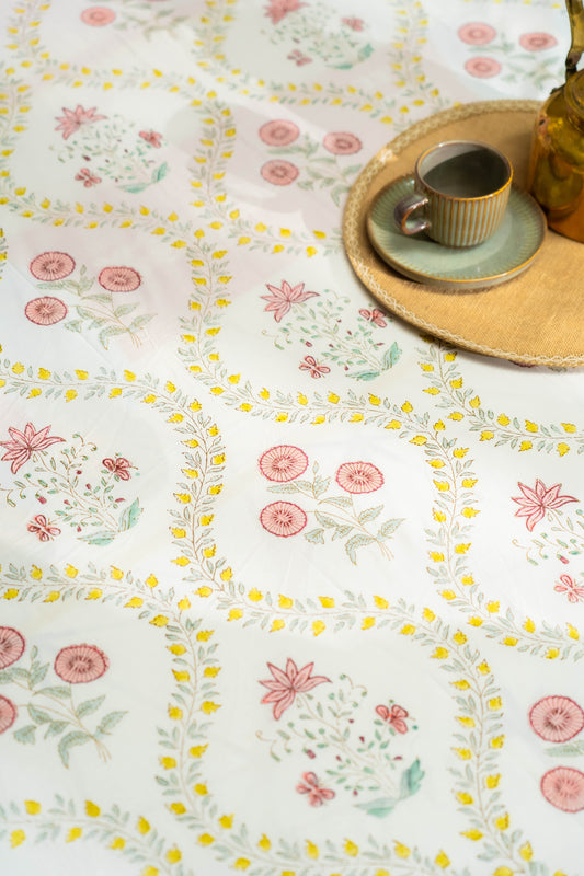 Floral patterned tablecloth with a cup and saucer on a wooden tray.