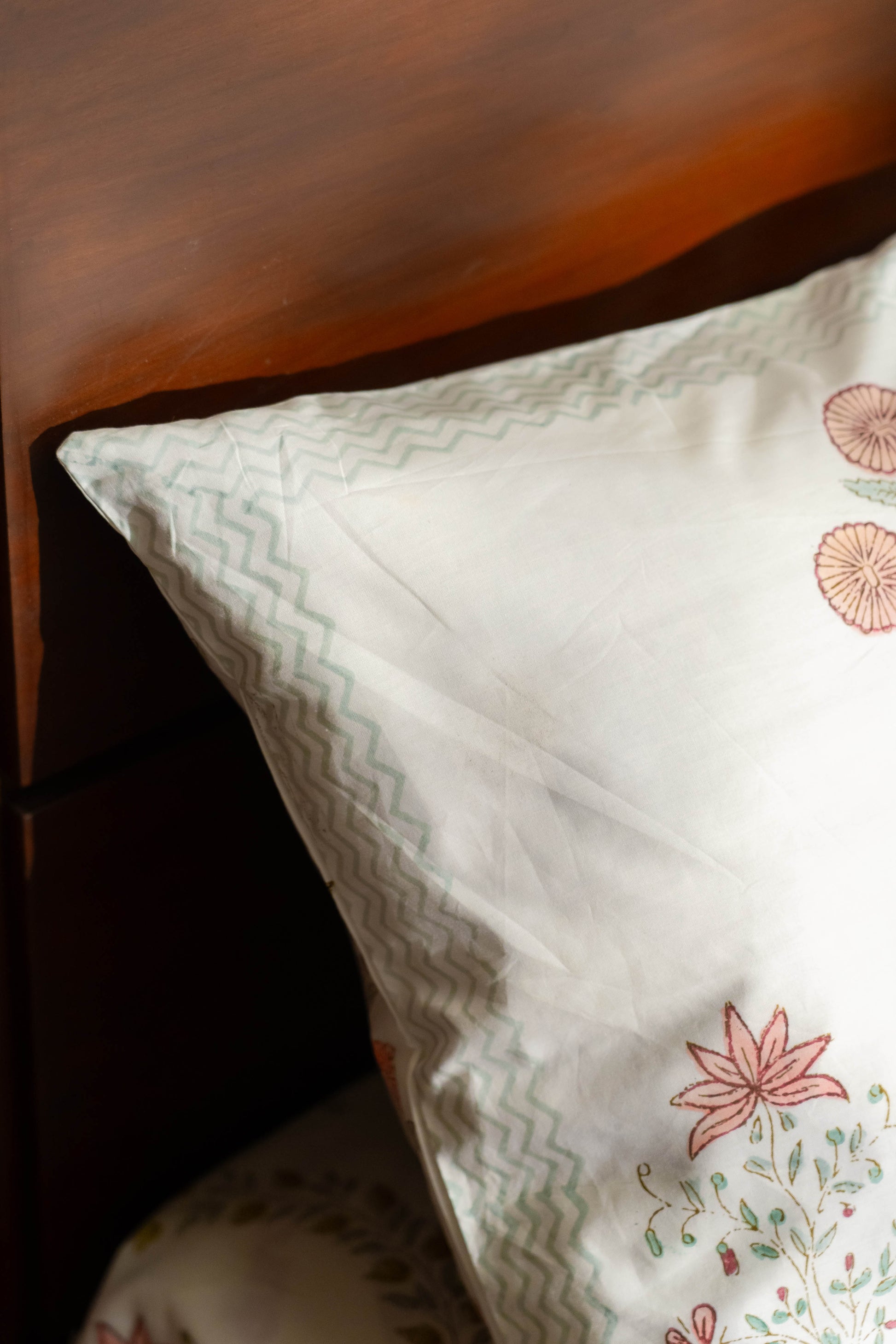 Decorative pillow with floral patterns on a wooden surface