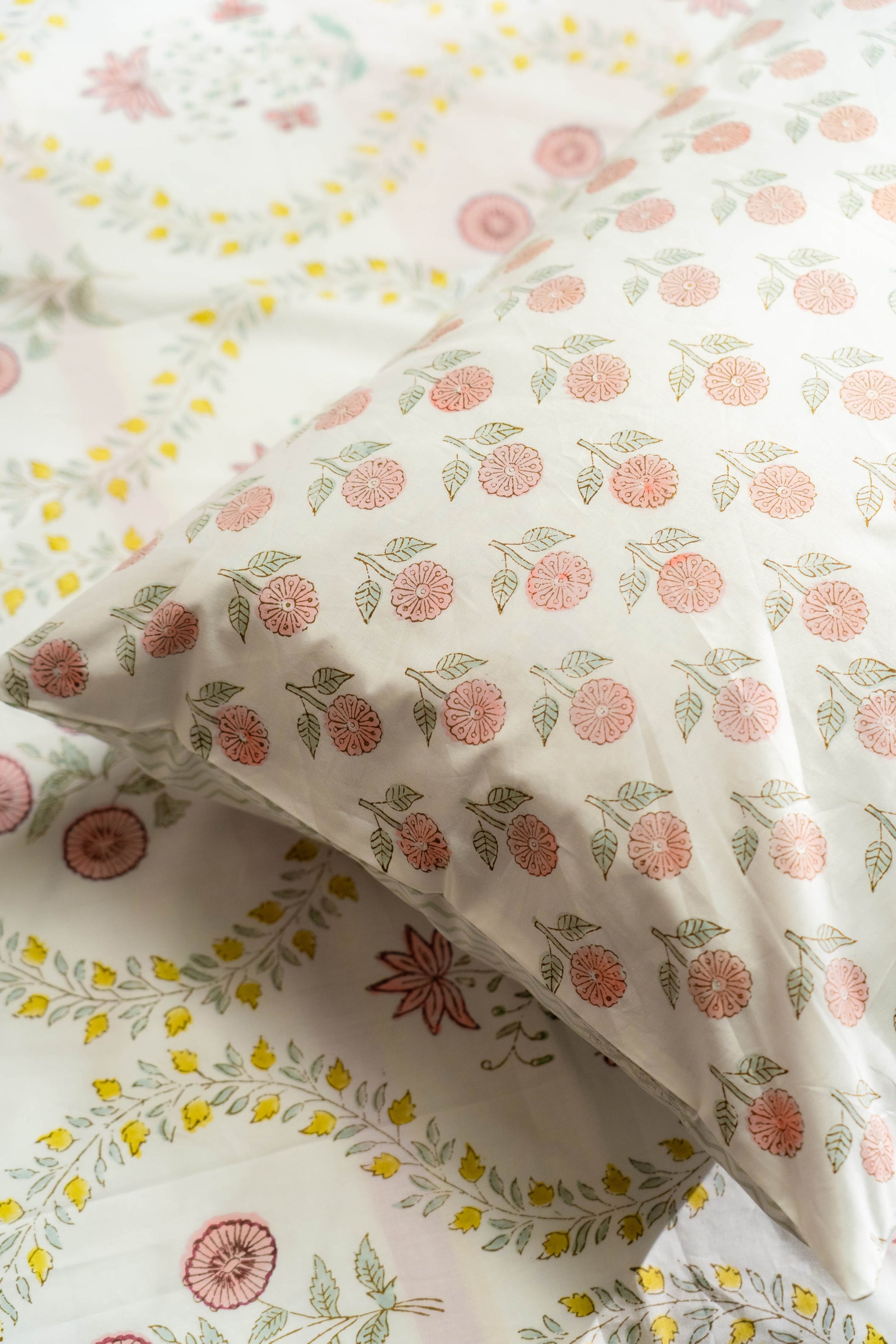 Floral patterned fabric with pink flowers and green leaves on a white background
