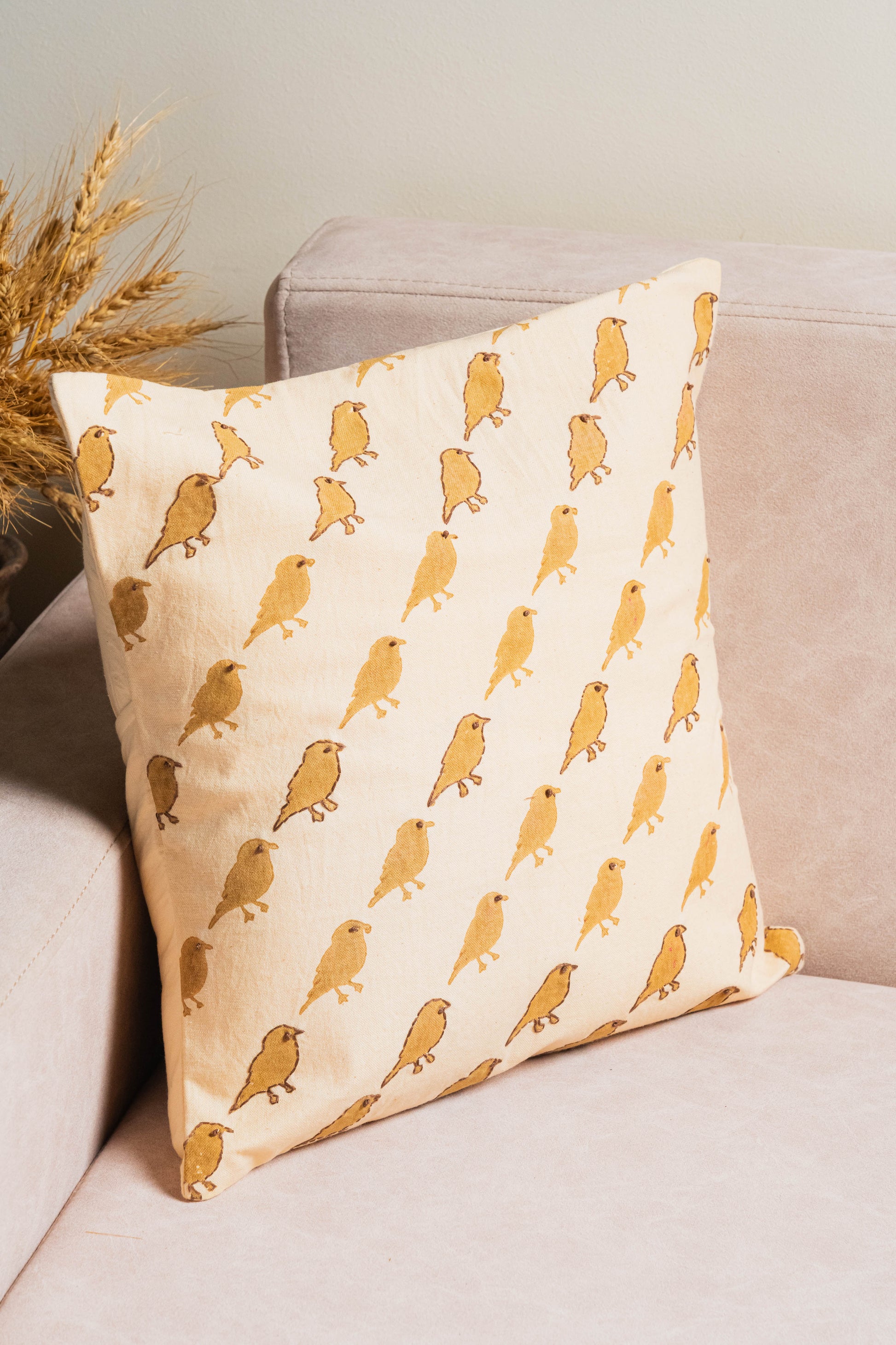 Decorative pillow with bird pattern on a beige couch