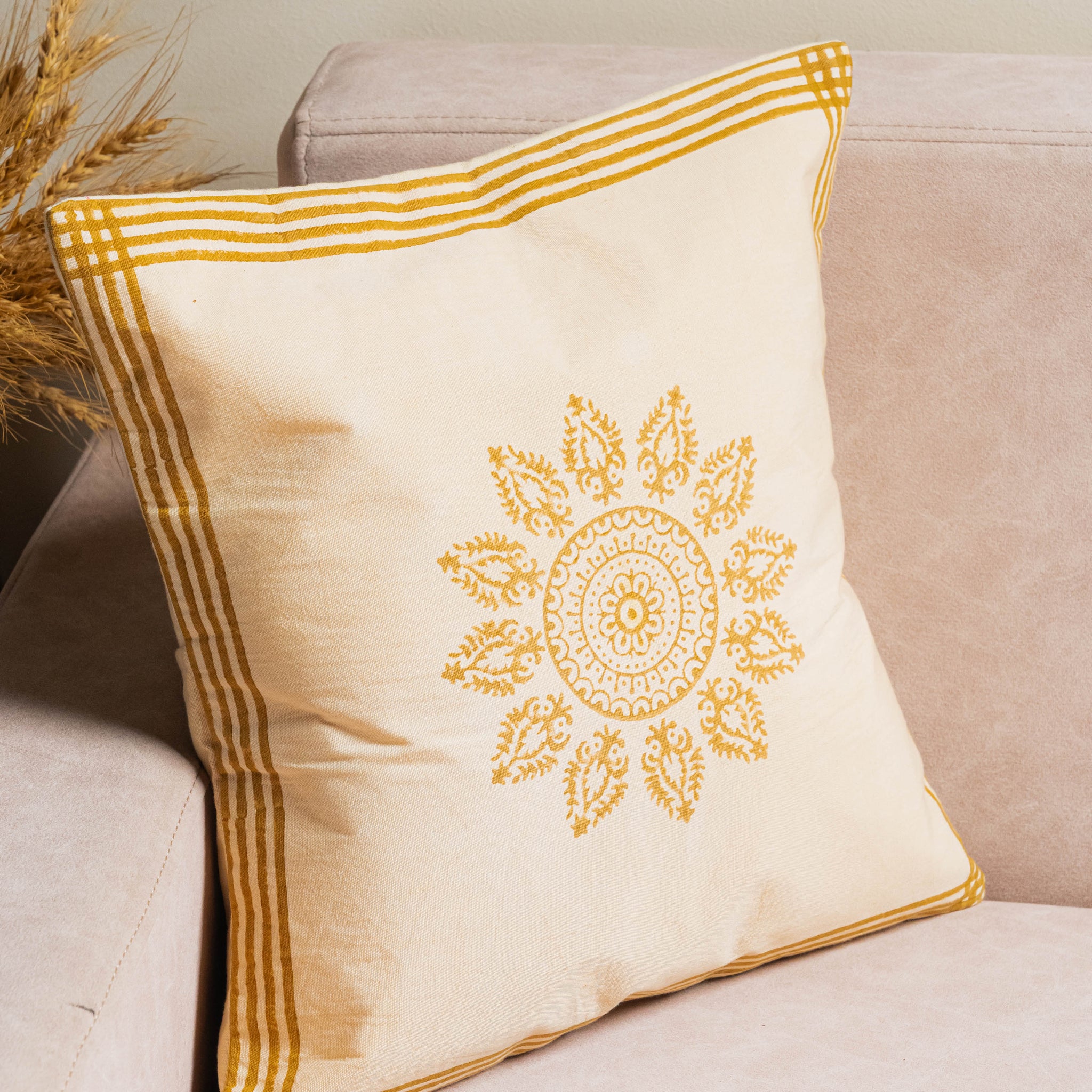 Decorative pillow with yellow embroidery on a beige couch