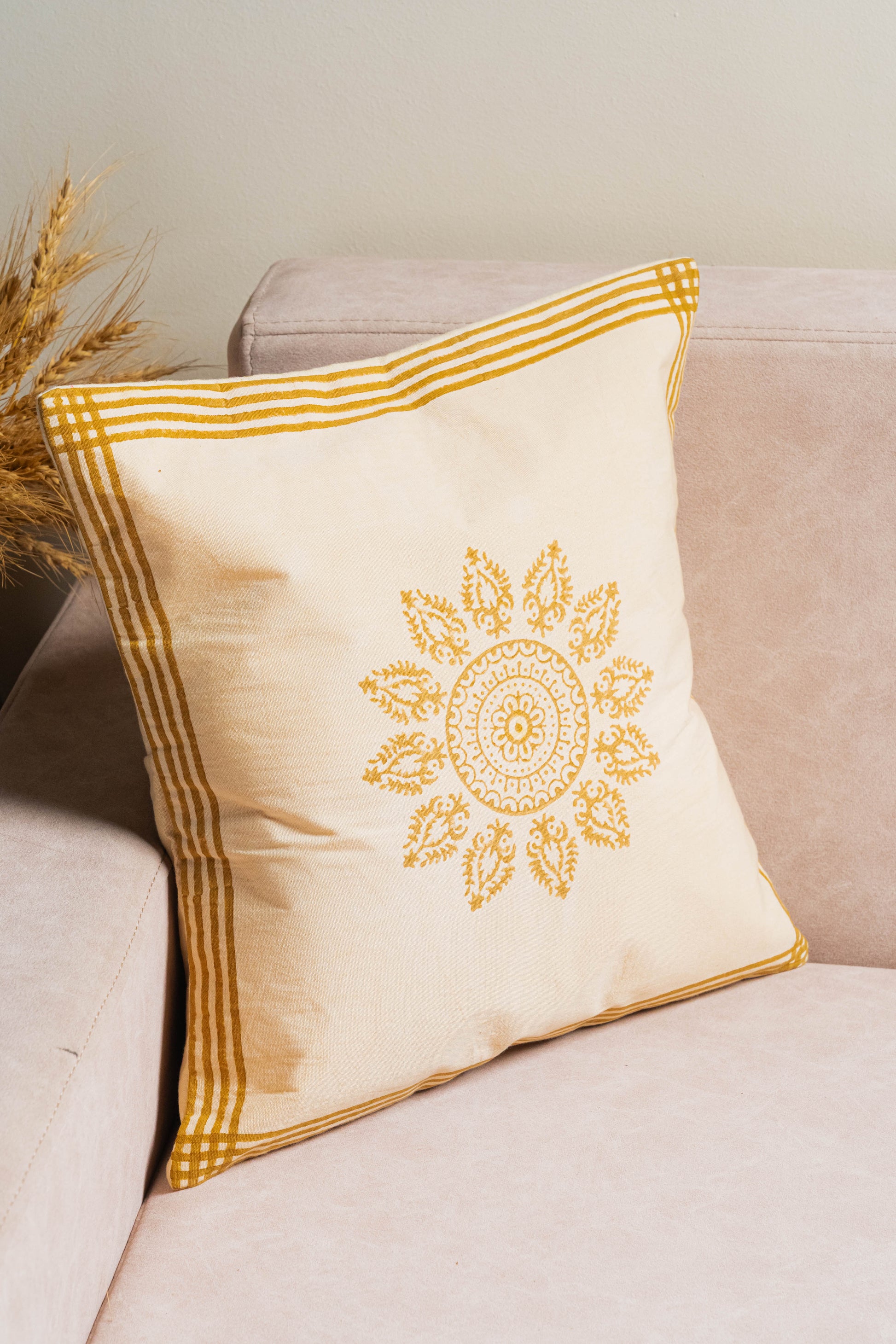 Decorative pillow with yellow embroidery on a beige couch