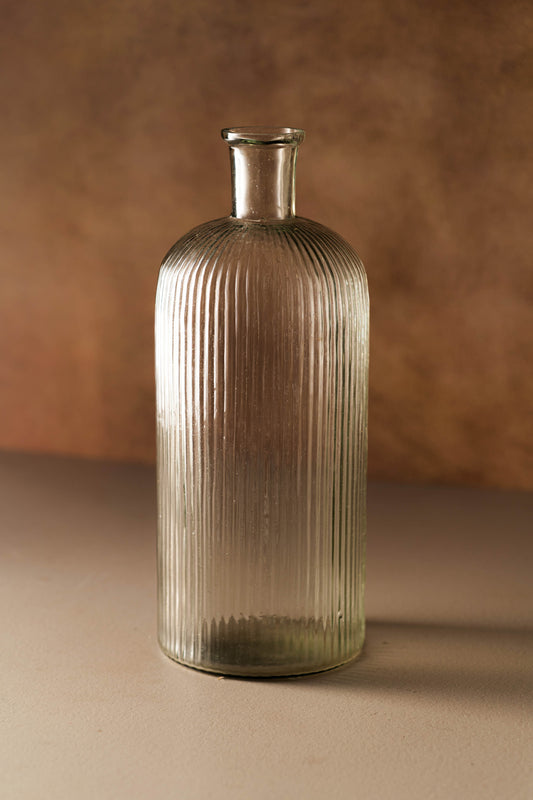 Glass vase with ribbed texture on a brown background