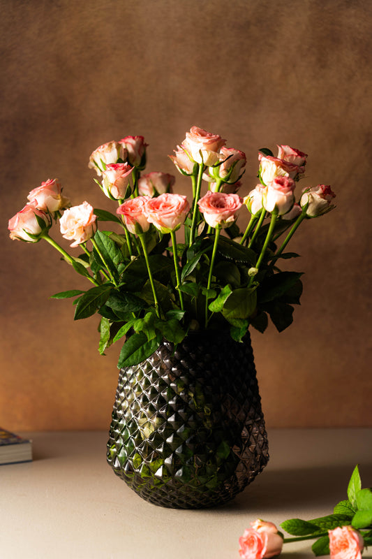 Bouquet of pink roses in a textured vase on a neutral background