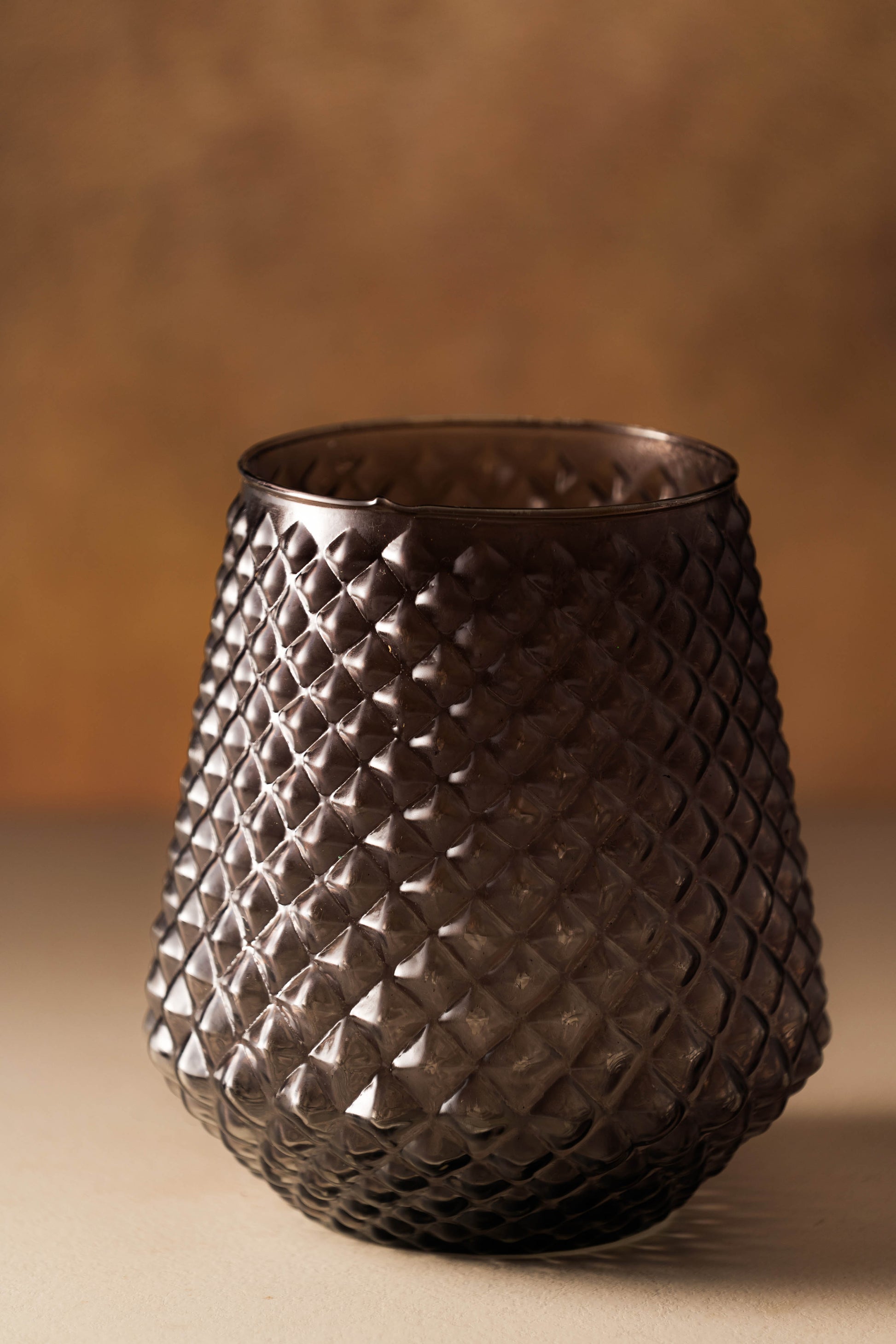 Decorative glass vase with woven pattern on a brown background