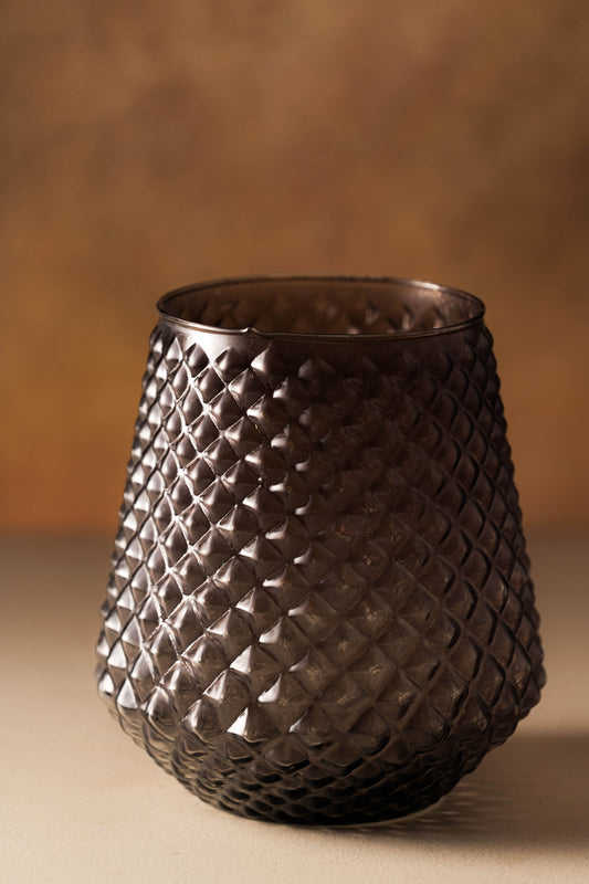 Decorative glass vase with woven pattern on a brown background