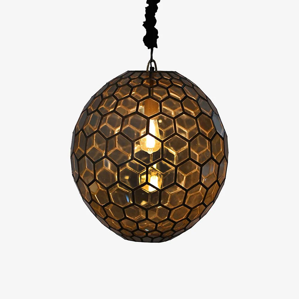  this handcrafted glass lamp features a striking hexagonal pattern enclosed in a golden metal frame. 