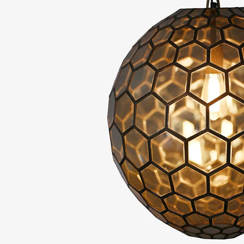 The rich, amber glow radiates softly through the textured glass panels, casting a cozy and artistic light across any room.