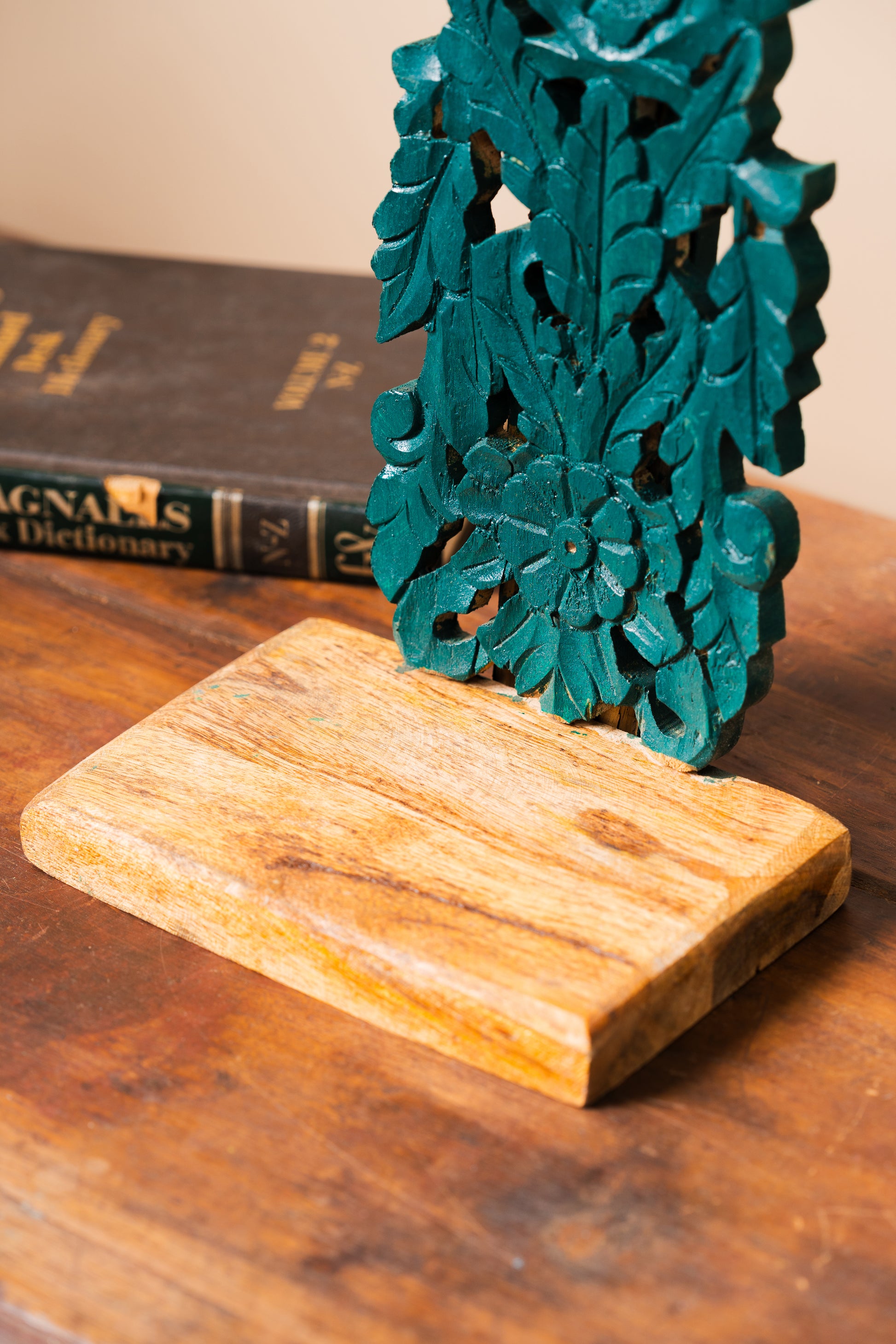 Hand-carved wooden stand, Green wooden stand, Functional art stand, Plant holder stand, Decorative object stand, Brass artefact display, Skilled artisan stand, Rustic wooden stand, Ornate wooden stand, Natural motif carving, Geometric pattern stand, Cultural symbol décor, Green finish stand, Wall-mounted stand, Tabletop display stand, tesu 