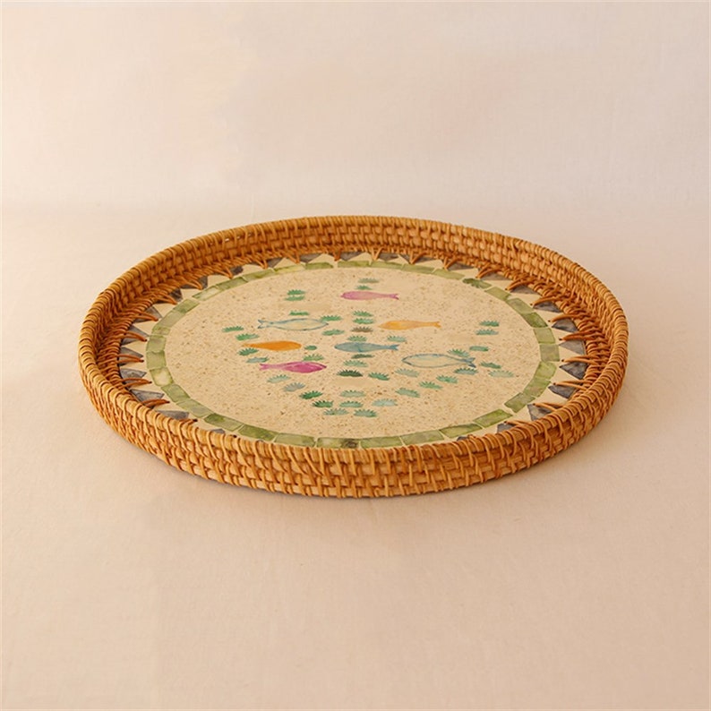 Enhance your Dream Home with our curated selection of premium Home Décor items. Round Mother Of Pearl Rattan Tray is made with handwoven rattan material mixed mother of pearl Impress your guests with these beautiful hand woven serving trays made with natural Rattan. In effortlessly chic hand-woven round tray has a designer motifs on it which makes it a center of attraction. TESU