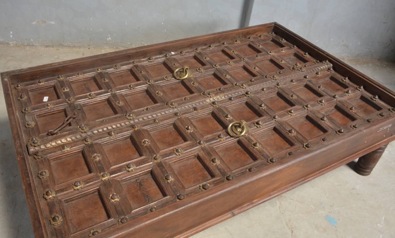 Haveli Door Coffee Table crafted from reclaimed wood, featuring an antique haveli door-inspired design with intricate hand-carved details and a rustic natural finish,