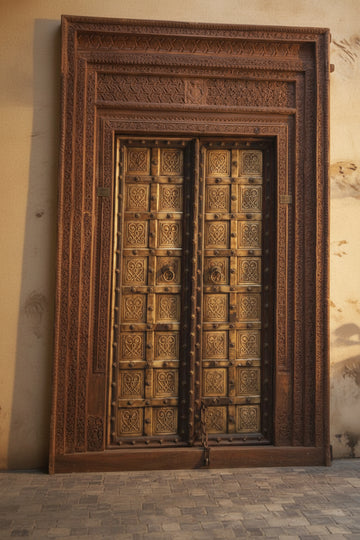 Decorative wooden door with intricate carvings on a plain wall.