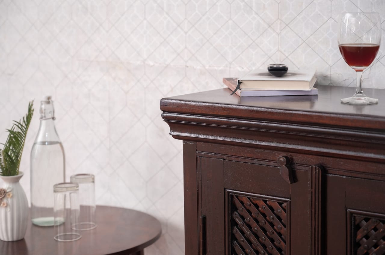 The beautifully carved wooden doors, adorned with antique brass handles, evoke a timeless charm, making it a perfect blend of traditional craftsmanship and modern functionality.