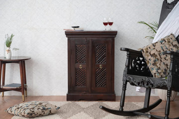 Designed with intricate latticework panels and a rich, dark finish, this vintage-inspired piece adds a touch of regal elegance to any room.