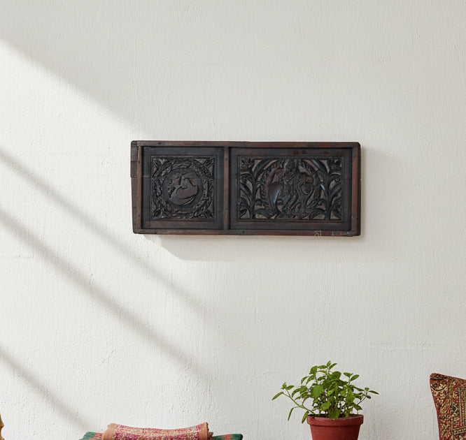 An antique carved wooden panel with two rectangular sections, featuring intricate relief carvings of a swan and a figure in foliage, finished in dark brown wood.