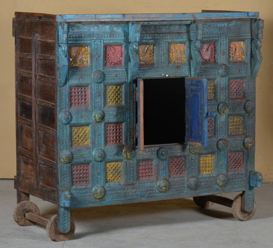 The carved wooden wheels and original patina add to its vintage charm, making it perfect as a console, statement cabinet, or heirloom décor.