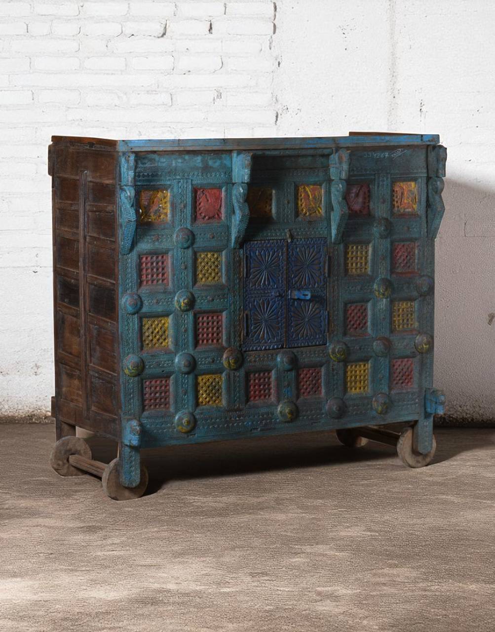 The carved wooden wheels and original patina add to its vintage charm, making it perfect as a console, statement cabinet, or heirloom décor.