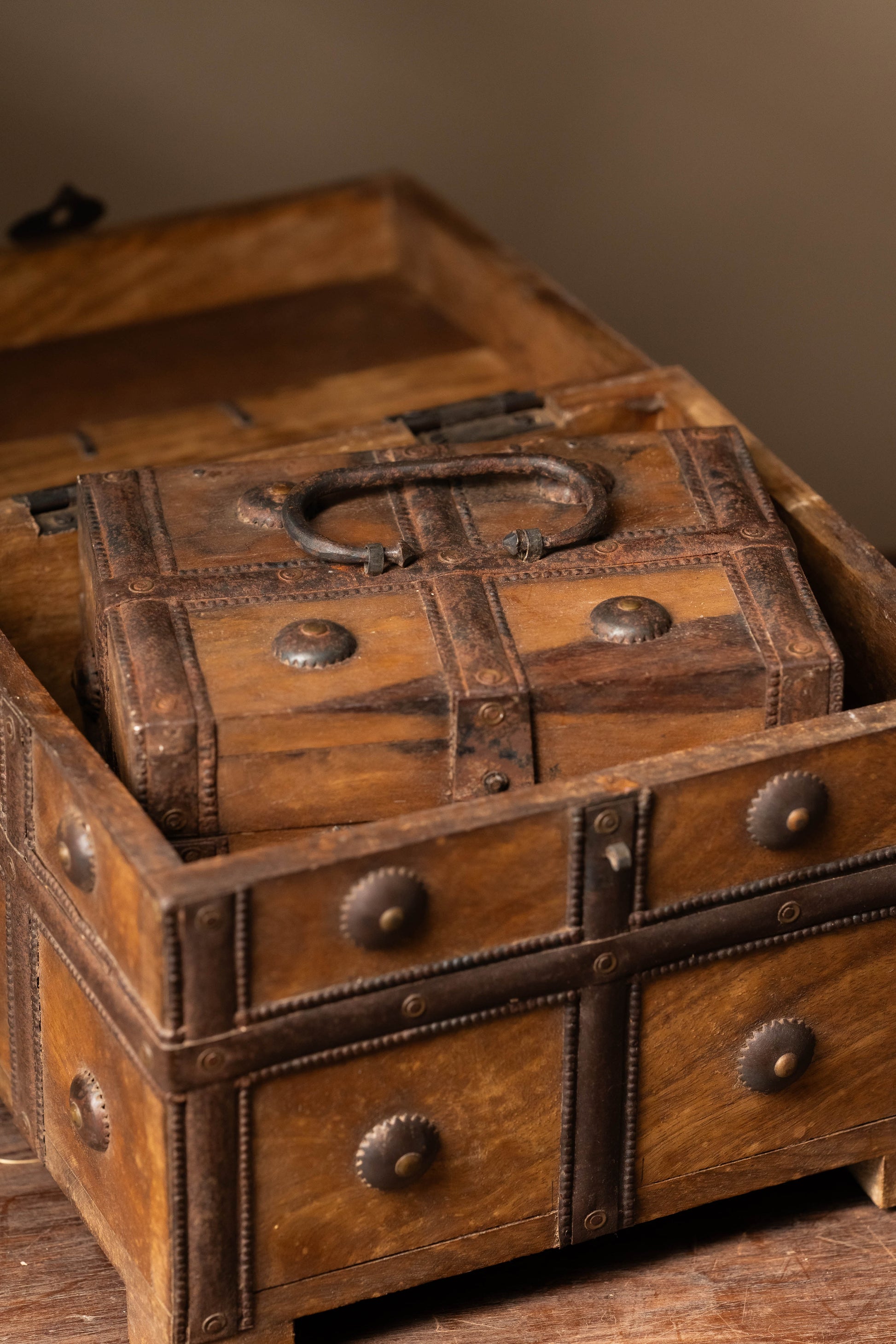 The chest is reinforced with iron bands, rivets, and a vintage latch, enhancing both its aesthetic charm and strength.