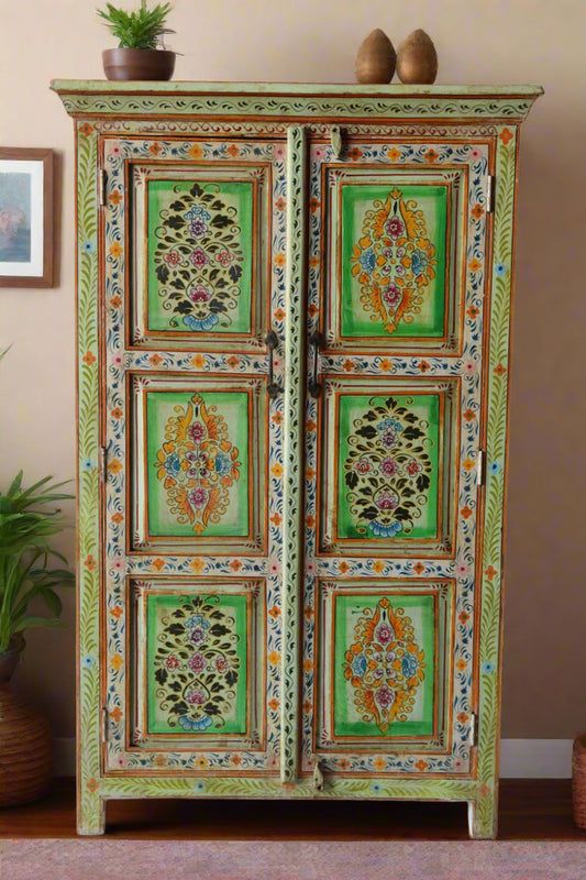 Decorative cabinet with floral patterns against a white brick wall.