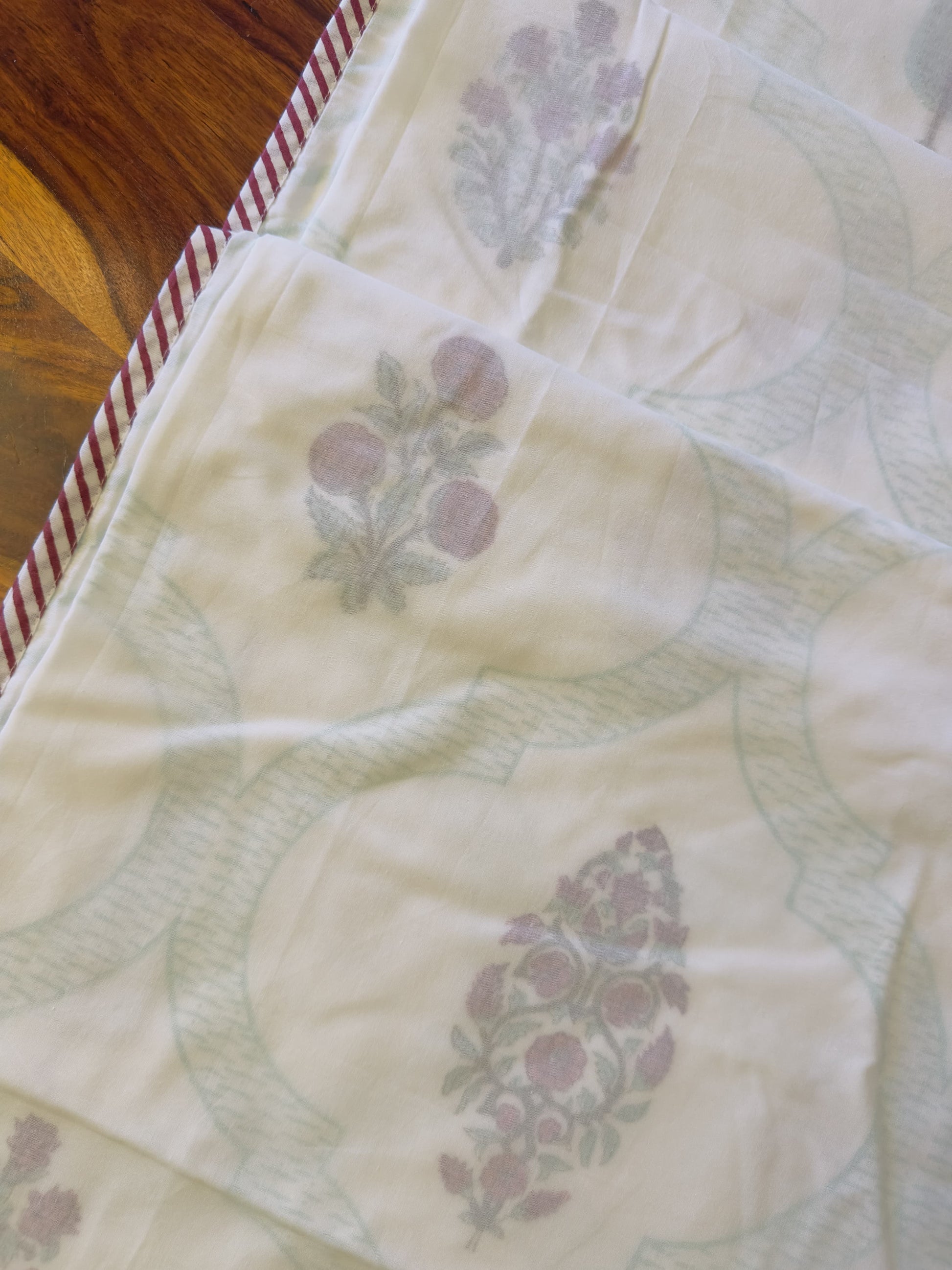 Floral patterned fabric with a wooden surface in the background