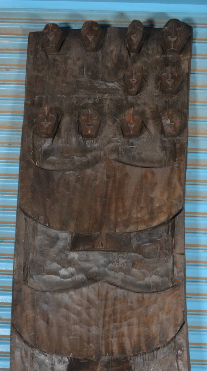 Wooden mask with carvings on a blue background