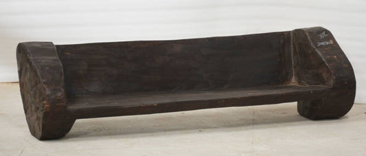 Wooden bench with a dark brown finish on a light wooden floor.